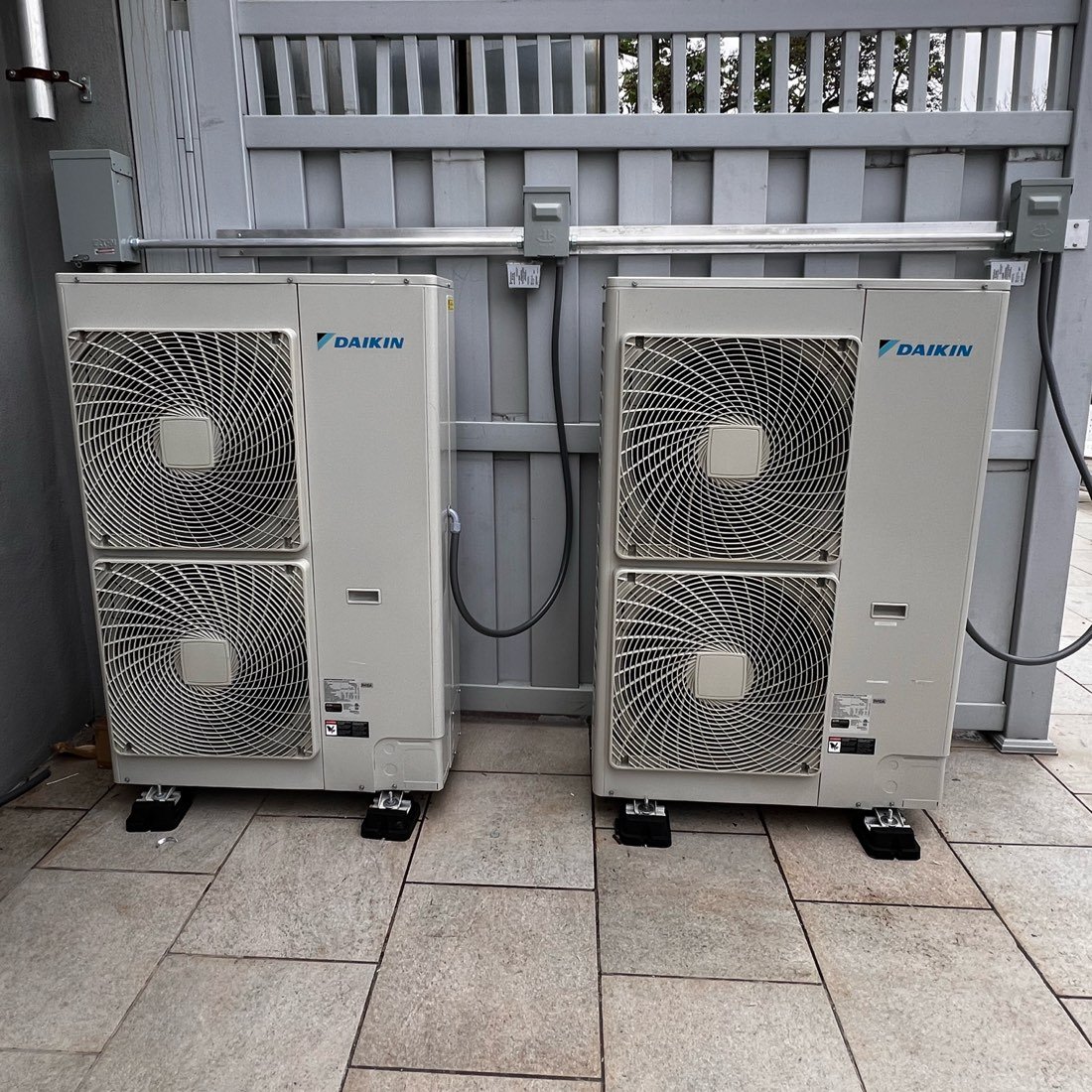 Two Daikin multi-zone outdoor units installed side by side on a patio
