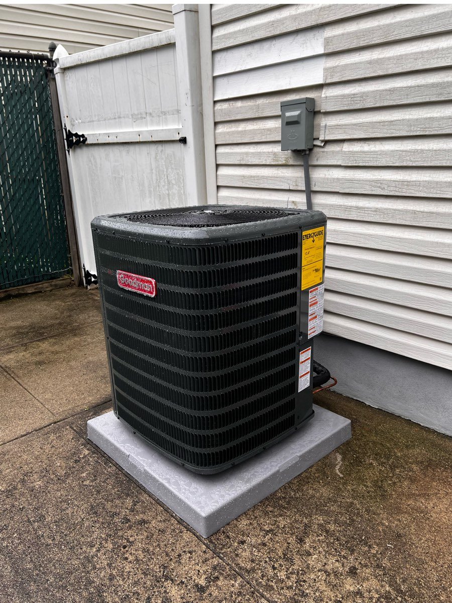 Goodman outdoor air conditioning condenser on a pad beside a home