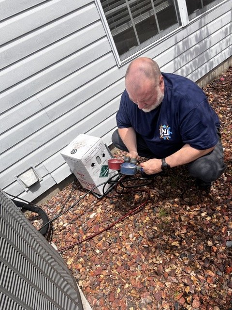 LNL technician charging an outdoor air conditioning system with refrigerant